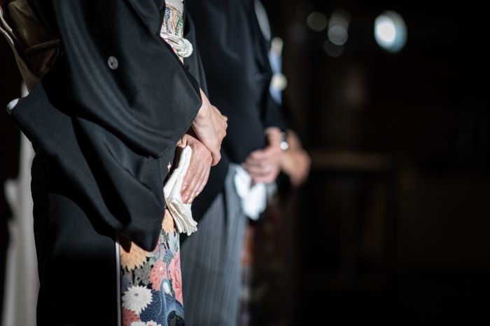 結婚式で黒留袖を着る母親。